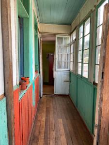 un pasillo vacío de una casa antigua con una puerta y ventanas en Hostal brons, en Valparaíso