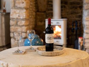 a bottle of wine sitting on a table with two glasses at Fairview Cottage in Moreton in Marsh