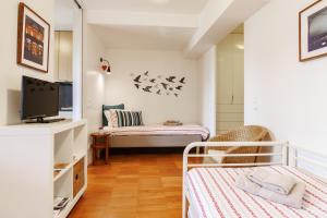 Habitación pequeña con 2 camas y TV. en Studios Cedofeita, en Oporto