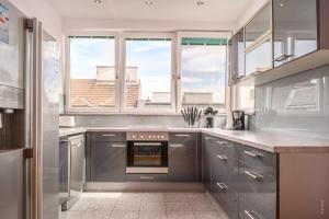 a kitchen with stainless steel appliances and a window at Designer Apartments, 2 min to U1 Reumannplatz in Vienna