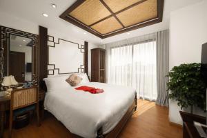 1 dormitorio con cama, escritorio y ventana en Veshia Hotel & Spa, en Hanói