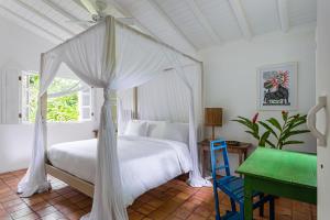 Un dormitorio con una cama blanca con dosel. en UXUA Alma, en Trancoso
