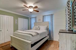 Un dormitorio con una cama con ventilador de techo. en Sunset Oasis by the Boondocks, en Port Orange