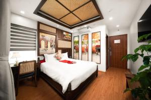Schlafzimmer mit einem großen weißen Bett und einem Schreibtisch in der Unterkunft Veshia Hotel & Spa in Hanoi