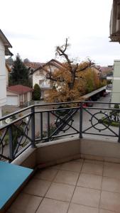 einen Balkon mit einem Tisch und Straßenblick in der Unterkunft Apartmani IVANA in Vrnjačka Banja