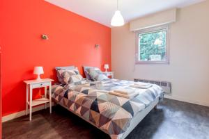 ein Schlafzimmer mit einem Bett mit einer orangefarbenen Wand in der Unterkunft Molinae in Saint-Juvat
