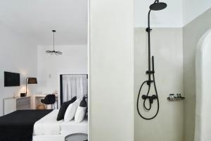 a bedroom with a black and white bed and a desk at Mr and Mrs White Santorini in Oia