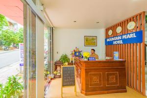 a man sitting at a counter in a restaurant at Mountain Pearl Hotel in Cat Ba