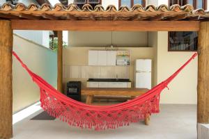 a red hammock in the kitchen of a house at Quintal da Arte Suites in Arraial d'Ajuda