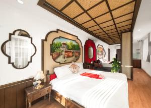 sypialnia z dużym białym łóżkiem i lustrem w obiekcie Veshia Hotel & Spa w mieście Hanoi