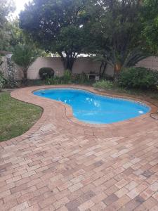 una piscina con un camino de ladrillo a su alrededor en Sol Montis Guest Cottage, en Paarl