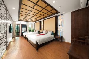 a bedroom with two beds and a couch at Veshia Hotel & Spa in Hanoi