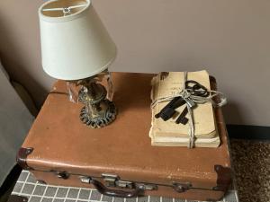 a lamp on a table with a suitcase and a book at BLQ 01boutique B&B in Bologna