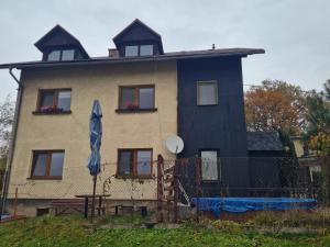 ein Haus mit einem blauen Regenschirm davor in der Unterkunft Malebný Rodinný Dům v Přírodě, Sauna, BBQ in Třinec