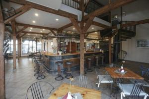 a bar in a restaurant with tables and chairs at Branša in Telšiai