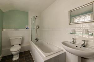 a white bathroom with a toilet and a sink at Bower House Inn in Eskdale