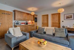een woonkamer met 2 banken en een tafel bij Apartment le Paradis 1 - Alpes Travel - Central Chamonix (sleeps 4) in Chamonix-Mont-Blanc