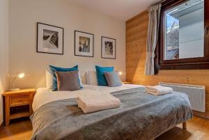 een slaapkamer met een groot bed en een raam bij Apartment le Paradis 1 - Alpes Travel - Central Chamonix (sleeps 4) in Chamonix-Mont-Blanc