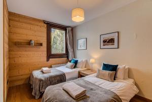 twee bedden in een kamer met houten wanden bij Apartment le Paradis 1 - Alpes Travel - Central Chamonix (sleeps 4) in Chamonix-Mont-Blanc