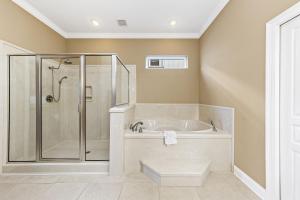 een witte badkamer met een douche en een bad bij Krusty Crab in Gulf Shores +34 foto's