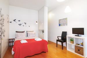 波多的住宿－Studios Cedofeita，一间卧室配有红色的床和电视