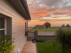 a porch of a house with a sunset in the background at La Maison d'Arc Chambres et Tables d'Hôtes in Frasnes-lez-Anvaing