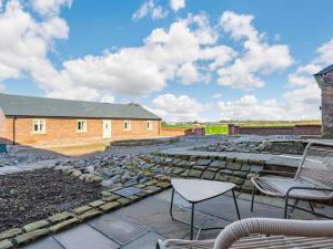 a patio with chairs and a table and a building at The Cottages at Ivy Farm by Charles Alexander Short Stay in Lytham St Annes