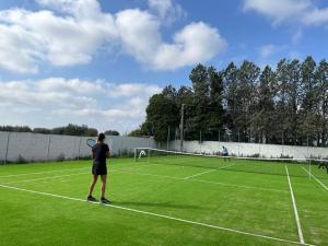 2 persone che giocano a tennis su un campo da tennis di Masseria Incantalupi a San Vito dei Normanni