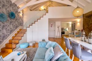 a living room with a blue couch and a staircase at Oporto Platinum Loft in Porto