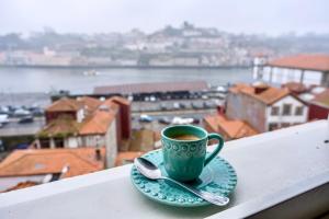 une tasse de café sur une assiette avec une cuillère dans l'établissement Oporto Platinum Loft, à Porto