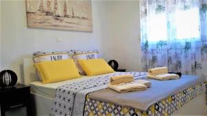 斯普利特Apartment Verdi Split with free private parking space的一间卧室，有两张床，配有黄色枕头