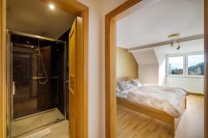 a bedroom with a bed and a walk in shower at Apartmán ZORA Family in Tatranská Lomnica
