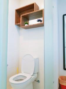a bathroom with a toilet with a shelf and a mirror at Simplicity Cozy For 2 -Trefoil Setia Alam- Near Setia City Mall-Setia Convention Centre in Shah Alam
