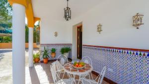 un patio con mesa, sillas y una pared de azulejos en Hacienda la Toscana Priego de Córdoba by Ruralidays, en Priego de Córdoba