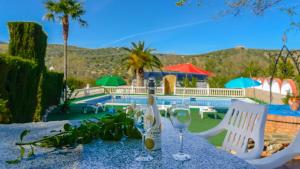 a table with a bottle of wine and two glasses at Hacienda la Toscana Priego de Córdoba by Ruralidays in Priego de Córdoba