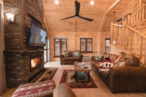 a woman sitting on a couch in a living room with a fireplace at Motel Long Lake and Cottages in Long Lake