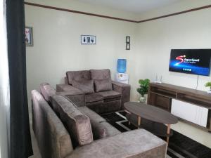a living room with a couch and a flat screen tv at Nash Issah Studio10 - 1bedroom in Nakuru