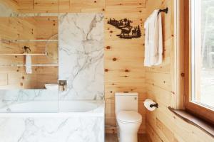 ein Badezimmer mit Badewanne, Toilette und Waschbecken in der Unterkunft Motel Long Lake and Cottages in Long Lake + 39 Fotos