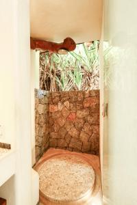 a bathroom with a shower with a stone wall at Beautiful Family House Beachfront 