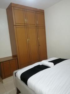 a bedroom with a bed and wooden cabinets at Nash Issah Studio10 - 1bedroom in Nakuru
