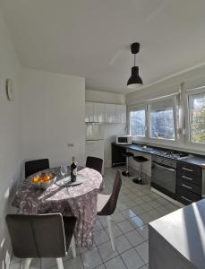 a kitchen with a table and chairs and a kitchen with a counter at Relax Central Apartment in Zagreb