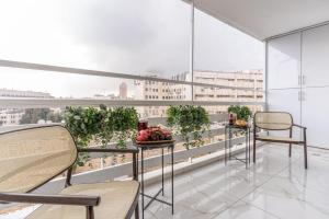 uma varanda com mesas e cadeiras e vista para a cidade em Renovated 2 BR with 2 BTH front Mamilla Mall em Jerusalém