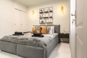 um quarto com uma cama cinzenta com almofadas em Renovated 2 BR with 2 BTH front Mamilla Mall em Jerusalém