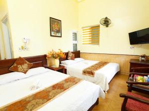 um quarto de hotel com duas camas e uma televisão em Lam Dat Hotel em Ninh Binh