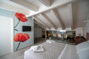 una camera da letto con un grande letto con fiori rossi sul muro di Profumi di Primavera Luxury Rooms a Matera