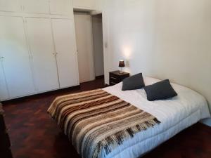 Un dormitorio con una cama con una manta. en Departamento Mendoza en Mendoza