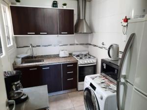 een kleine keuken met een fornuis en een wasmachine bij Departamento Mendoza in Mendoza