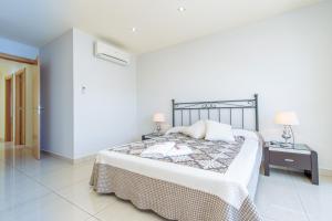 1 dormitorio con 1 cama y 2 lámparas en una mesa en Apart-rent Villa Ter 0031, en Empuriabrava