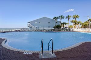 a large swimming pool with palm trees and a building at Gone Coastal - Tidewater Beach Resort #2410 by Book That Condo in Panama City Beach