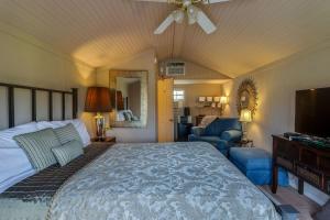 a bedroom with a large bed and a living room at Four Winds Victorian Venue & Suites in Bonham
